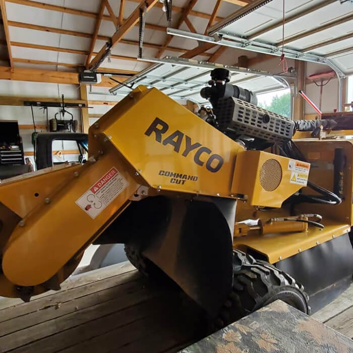stump grinder yellow and black rayco command cut parked inside garage barn on a trailer