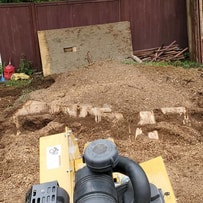 stump grinder sitting on customer property grinding a large stump